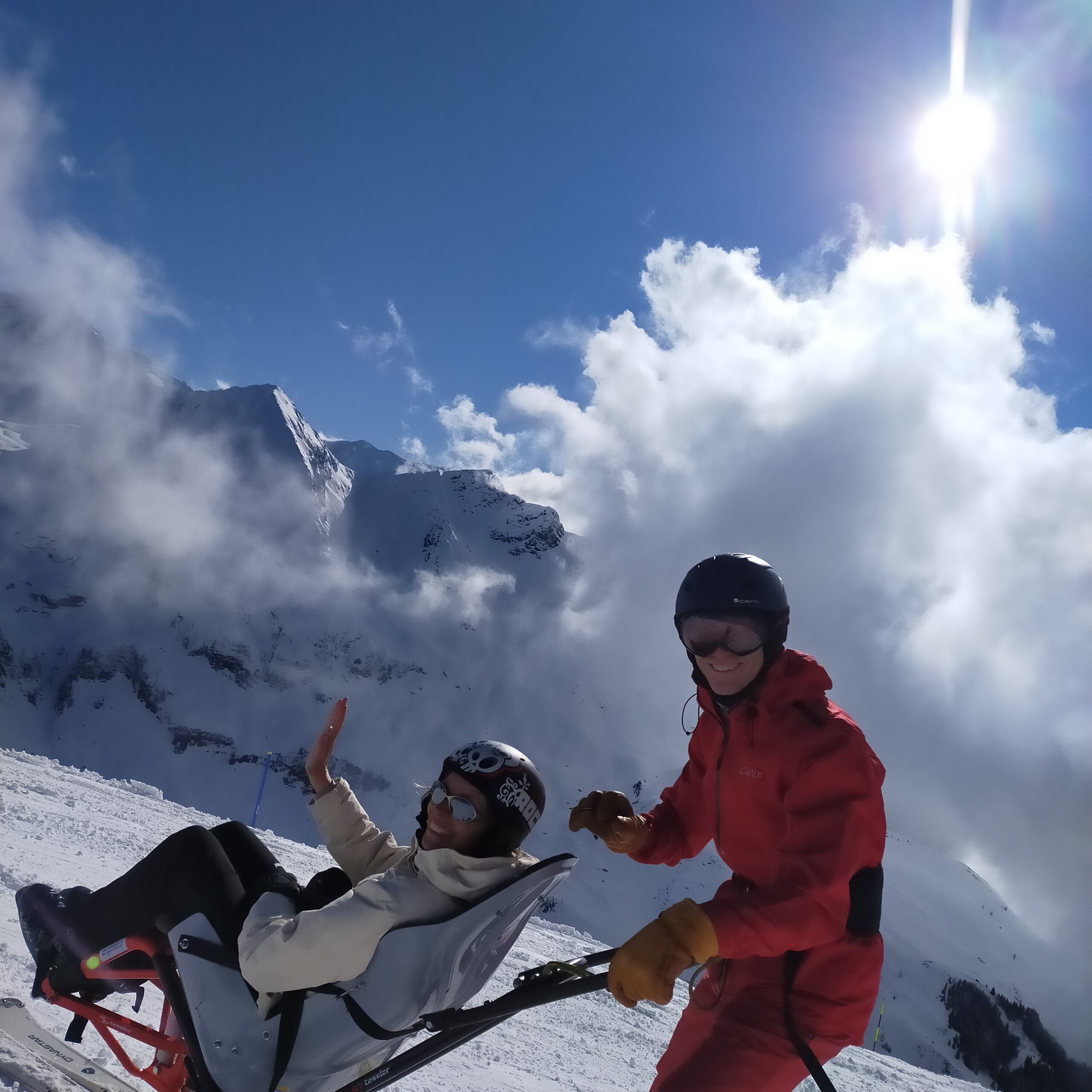 Deux sportifs pratiquant le ski en tandem, pris de côté.