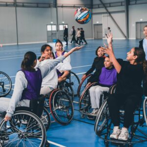 Plusieurs élèves essayant le rugby fauteuil, le ballon est en l'air.
