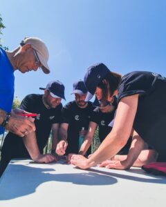 Personnes se rassemblant en équipe autour d'une table, vue en contre-plongée.