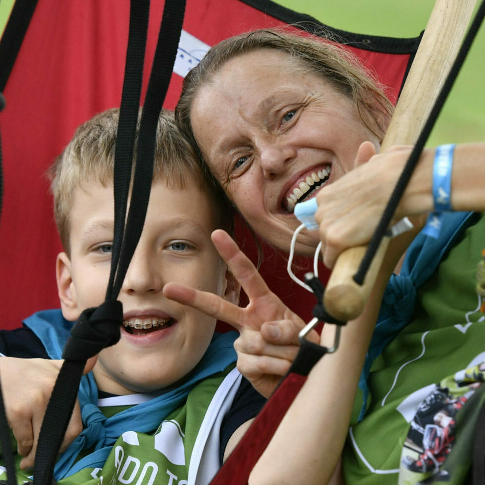 Une femme et un enfant entrain de faire de l'acrobranche adaptée pris de face.