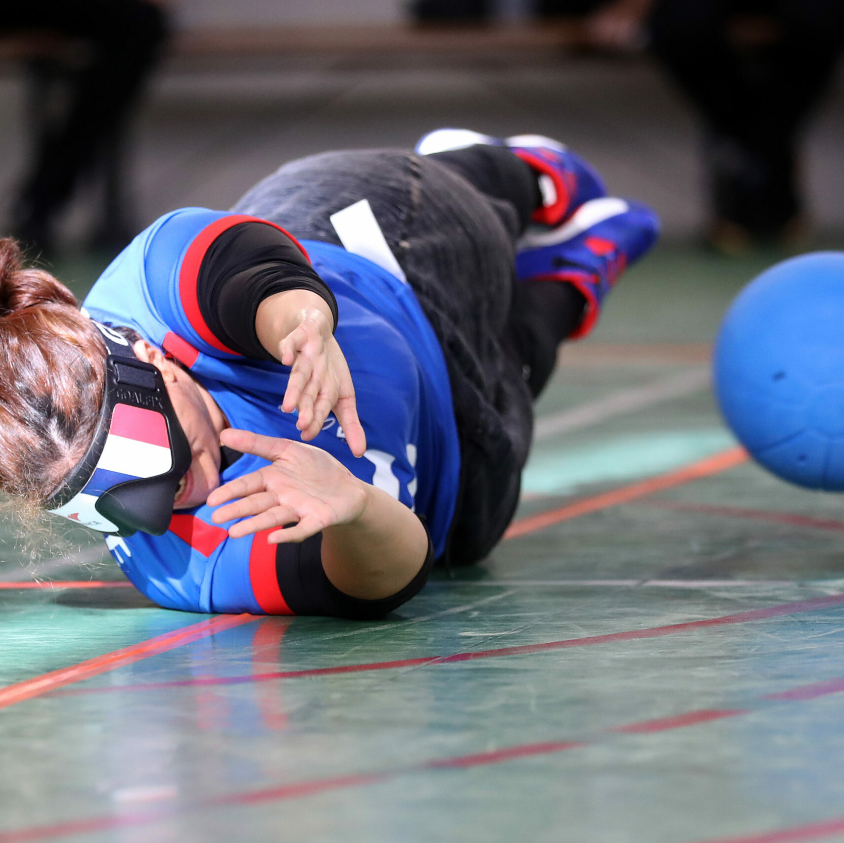Sportive qui rattrape le ballon au goalball, prise de côté. 