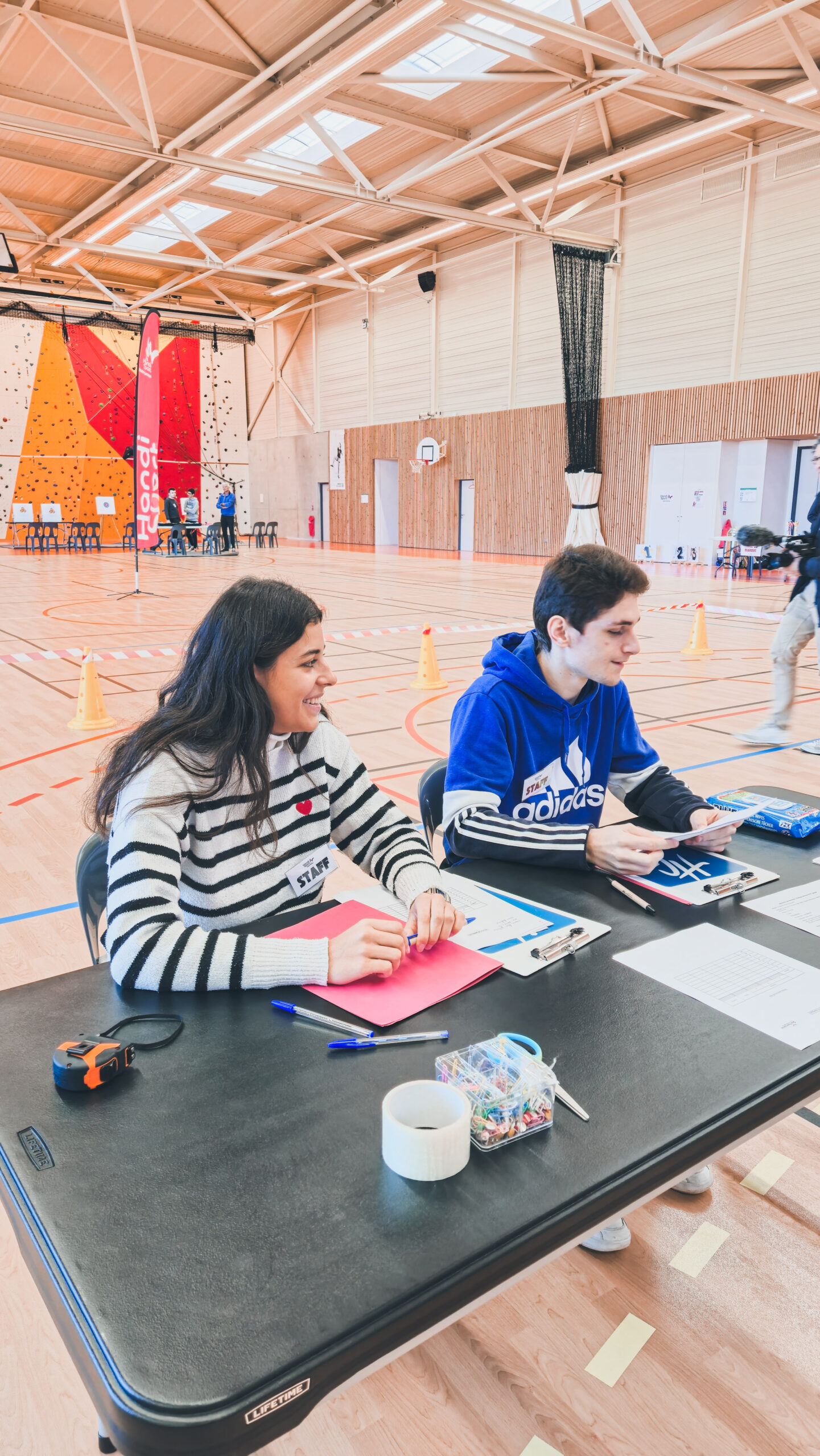 Deux arbitres assis à la table de marque et qui regardent sur le côté, pris sur le côté.