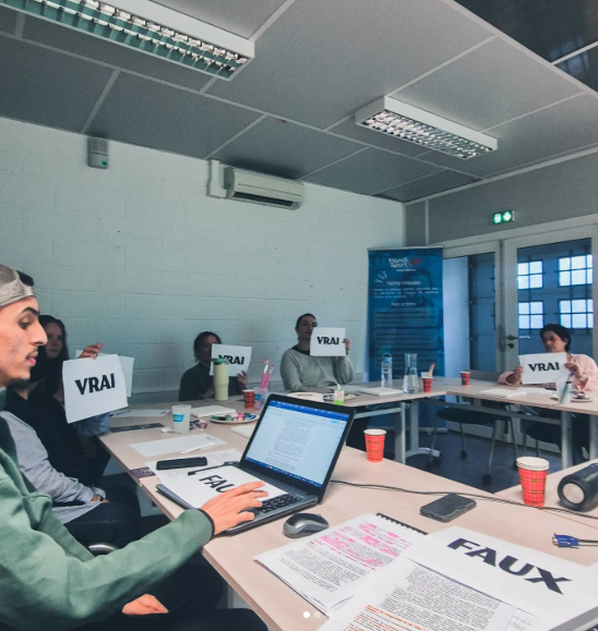 Les participants tiennent des pancartes vrai ou faux autour d'une table